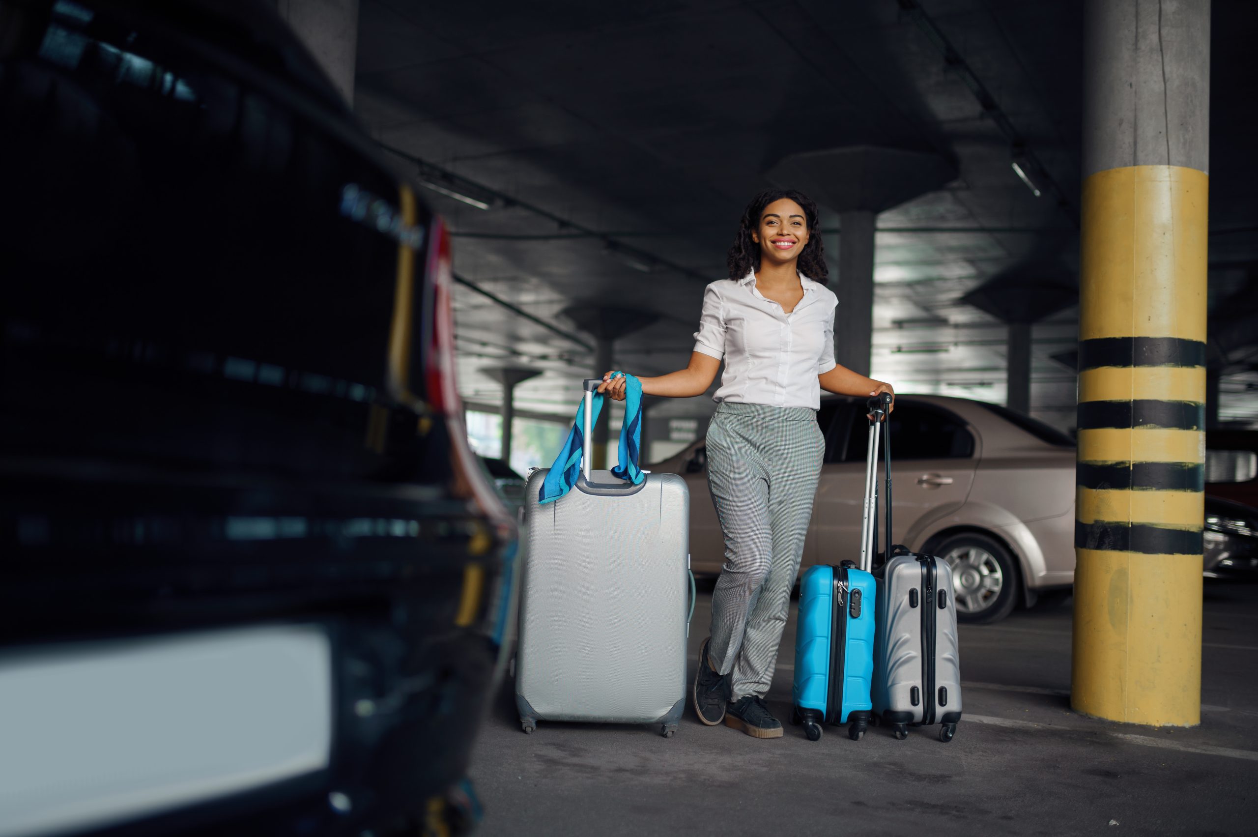 happy-woman-with-many-suitcases-in-car-parking-2023-11-27-05-06-43-utc